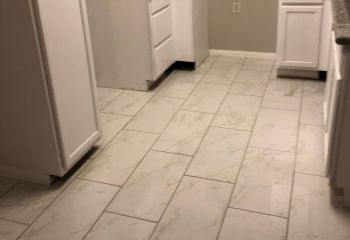 Newly remodeled Santa Clarita kitchen with marble pattern tile flooring and sleek custom cabinets.